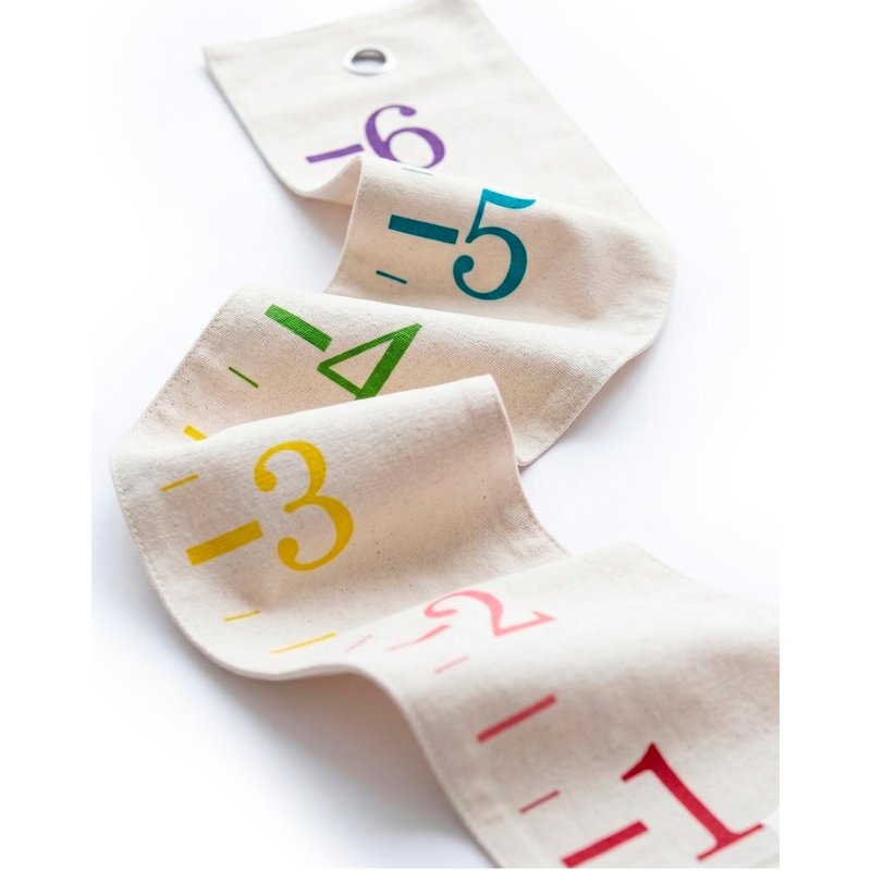 Cream canvas growth chart with rainbow-colored ruler numbers, shown unrolled